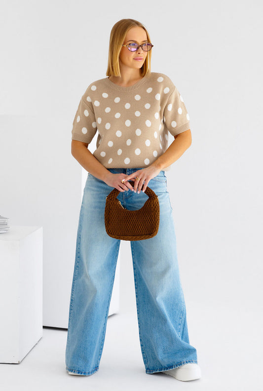 Model trägt gepunkteten Oversized Strickpullover in Beige mit Rundhalsausschnitt – Ganzkörperansicht