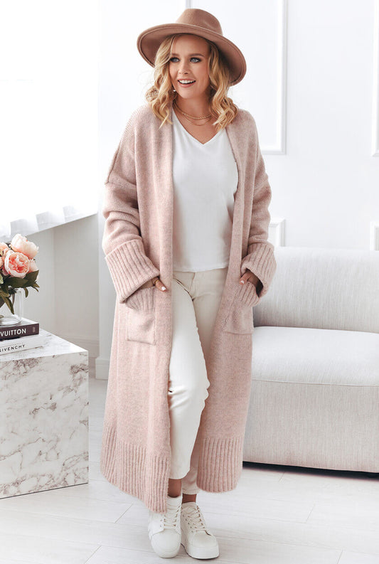 Oversized Strickmantel Puder Vorderansicht – extra lange hochgekrempelte Ärmel und große Seitentaschen – Stylelista