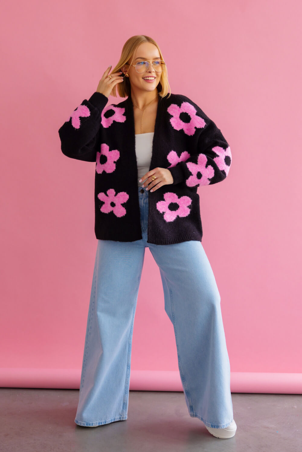 Modische schwarze Strickjacke mit rosa Blütenmuster und Oversize-Schnitt