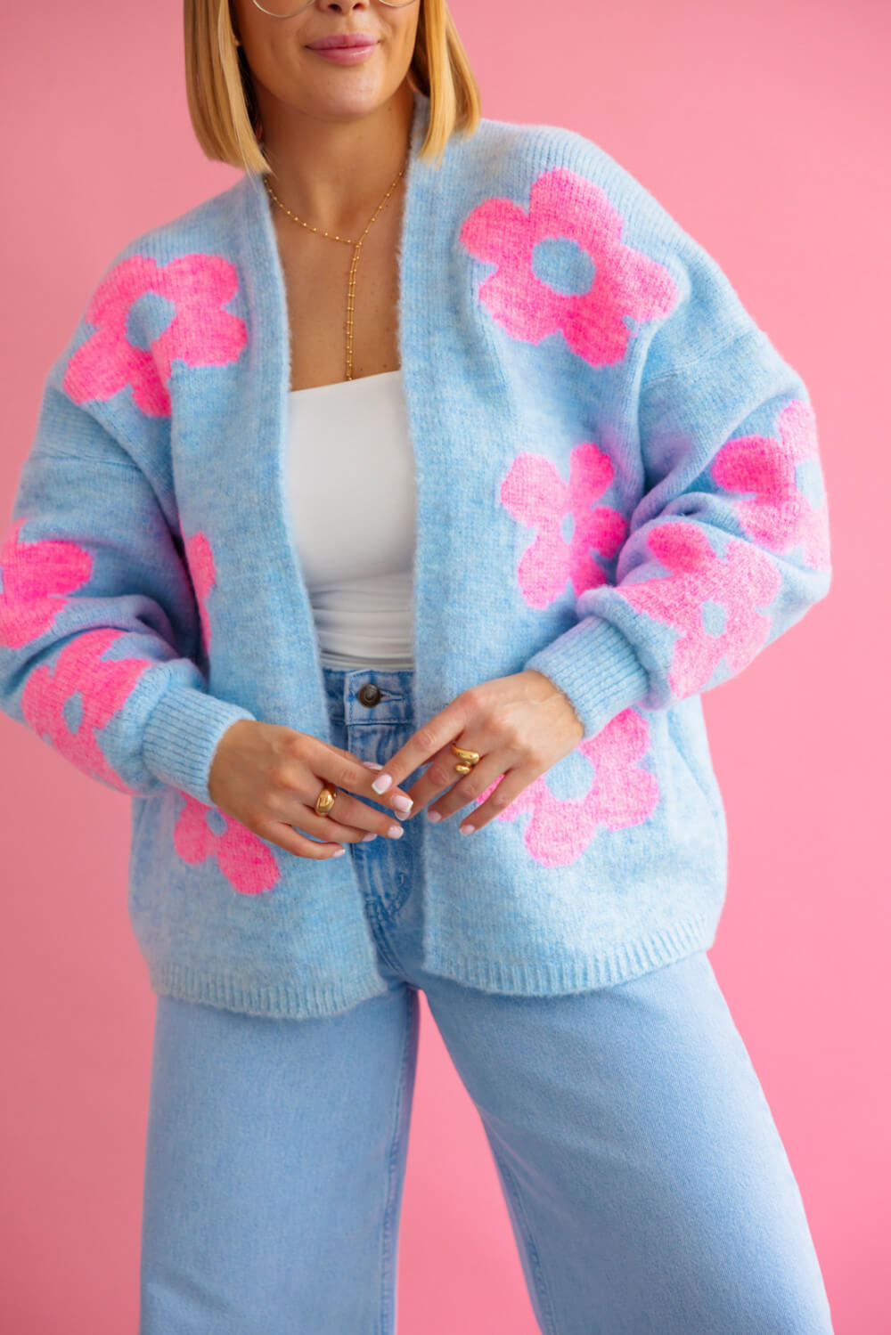 Detailaufnahme weicher Strickjacke mit pinken Blumen