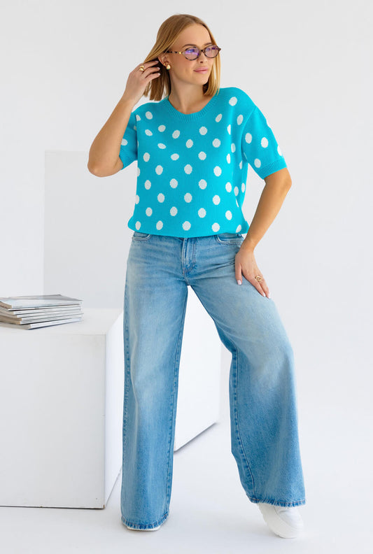 Polka Dots Strickpullover kurze Ärmel in Türkis mit weißen Punkten, kombiniert mit blauen Jeans.