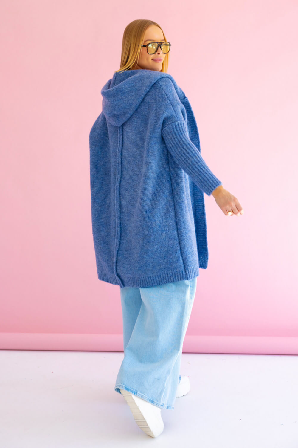 Rückansicht des Strickmantels in Tiefblau mit charakteristischer mittiger Rückennaht